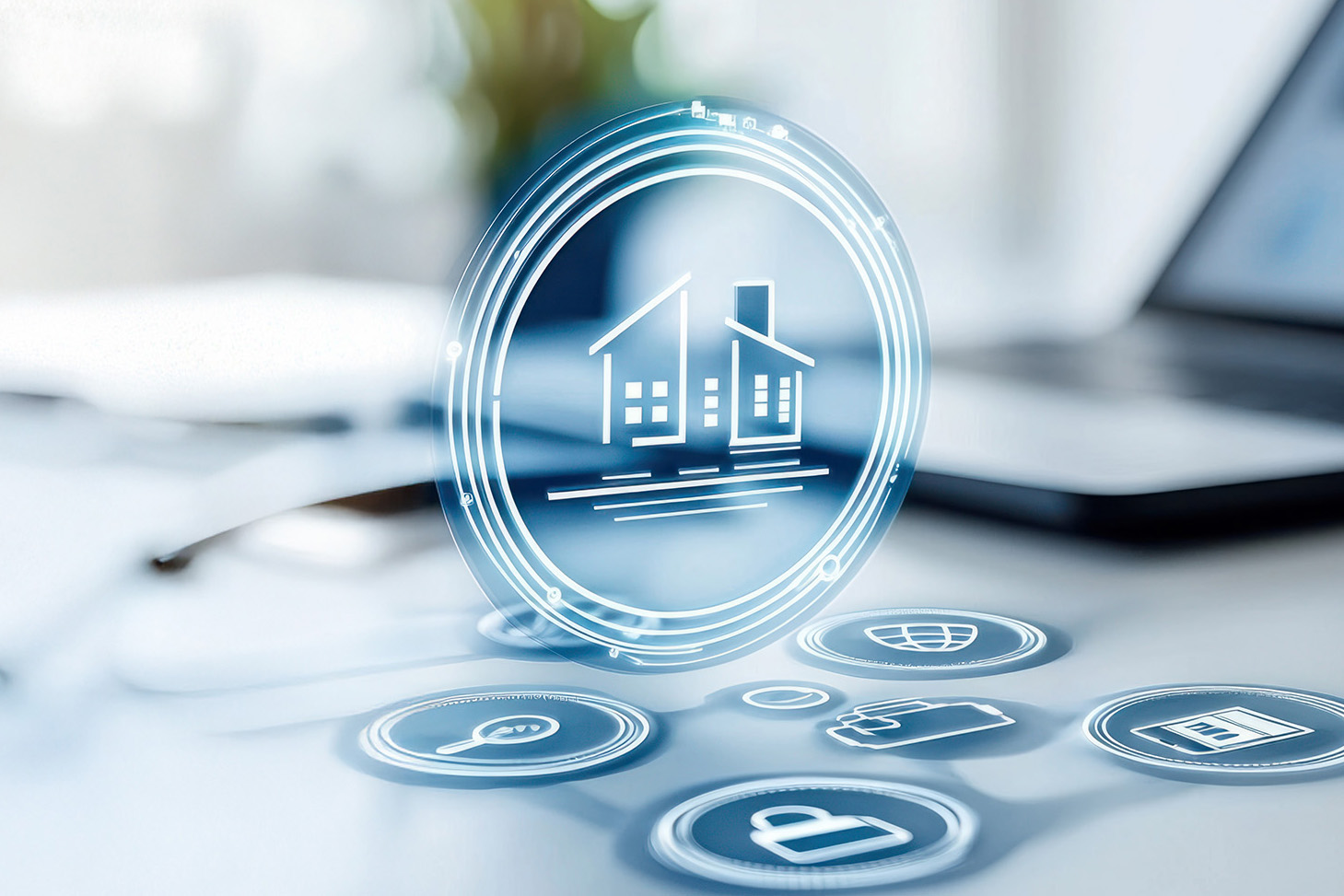 “Icona olografica di una casa stilizzata all’interno di un cerchio luminoso sospeso, circondata da altri simboli digitali sfumati su una superficie: un lucchetto, una lente di ingrandimento, una cartella, un globo e una finestra. Sullo sfondo si intravede un laptop e altri oggetti da scrivania, in contesto da ufficio.”